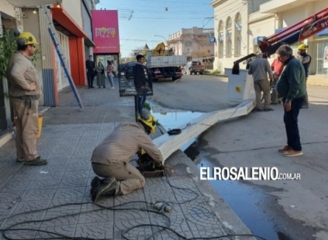 Un camión que transportaba una retroexcavadora volteó un cartel en pleno centro