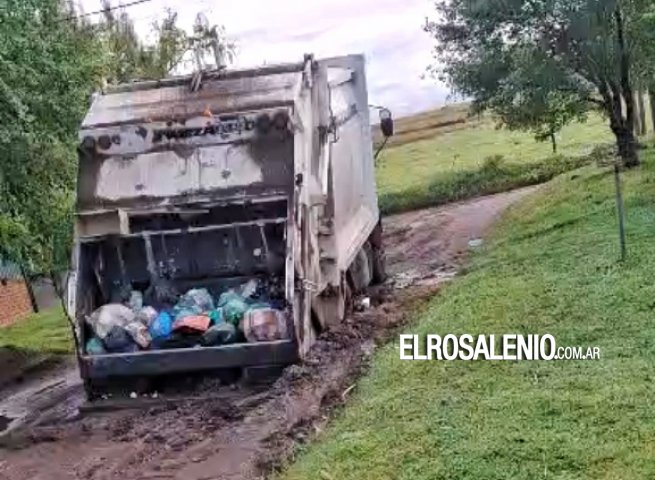 Dos camiones recolectores varados: uno encajado en calle de tierra, el otro roto en la ruta